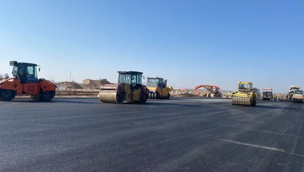 近日，在西部市政建設(shè)集團(tuán)蘭州新區(qū)城市礦產(chǎn)與表面處理產(chǎn)業(yè)園區(qū)（二期）周邊基礎(chǔ)設(shè)施項(xiàng)目—園區(qū)西路南延段（緯五十路至緯二十八路）項(xiàng)目現(xiàn)場(chǎng)，隨著一輛輛運(yùn)料車(chē)平穩(wěn)駛?cè)耄瑪備仚C(jī)將滾燙的瀝青混合料均勻鋪開(kāi)，標(biāo)志著項(xiàng)